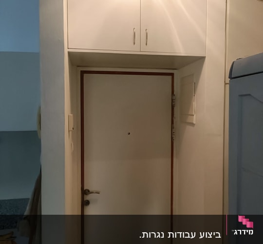 ארון עץ לבן מעל דלת כניסה